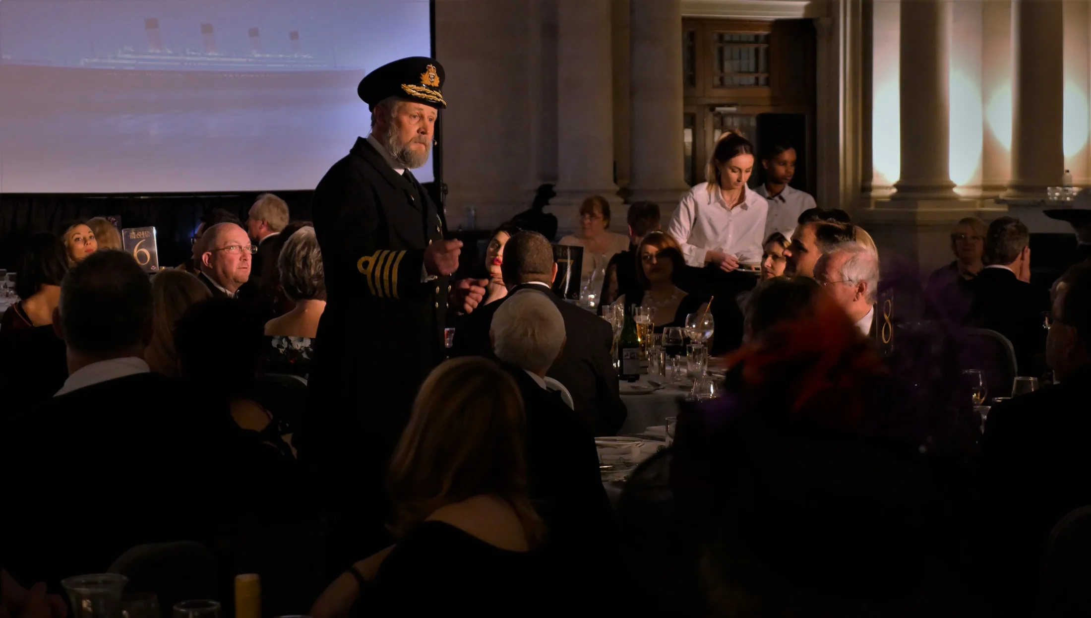 A Histoire performance taking place among tables of dinner guests